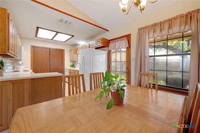 dining area with vaulted ceiling and a notable chandelier