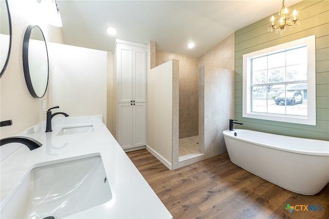 bathroom with separate shower and tub, vanity, vaulted ceiling, wood-type flooring, and an inviting chandelier