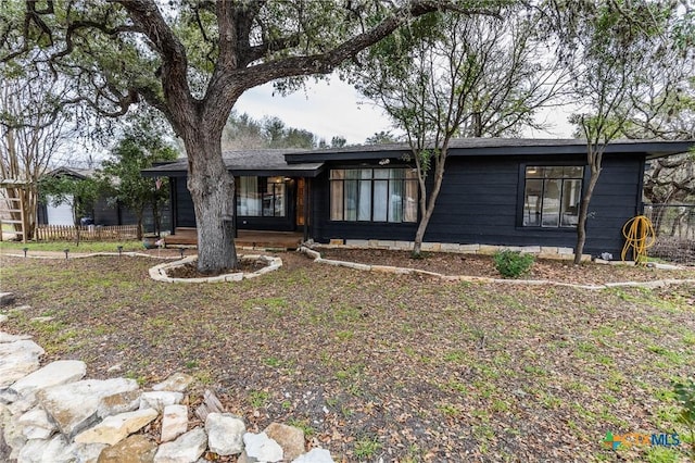 mid-century home featuring fence