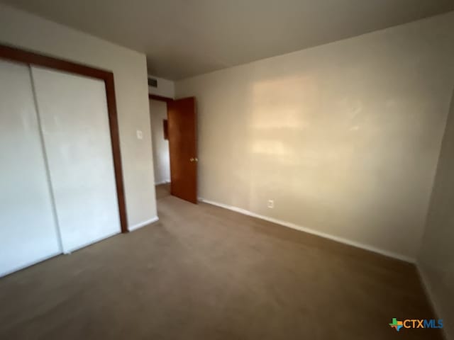 unfurnished bedroom with a closet and carpet