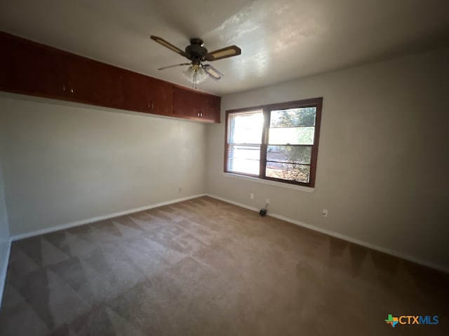 empty room with ceiling fan and carpet floors