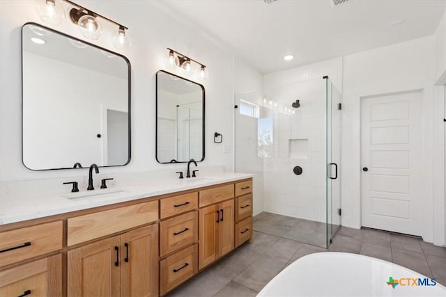 bathroom featuring a shower stall, double vanity, tile patterned floors, a soaking tub, and a sink