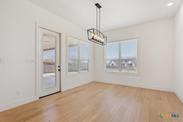 unfurnished dining area featuring recessed lighting, light wood-type flooring, baseboards, and a chandelier