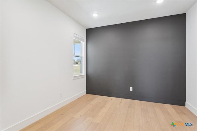 spare room with recessed lighting, baseboards, and light wood-type flooring