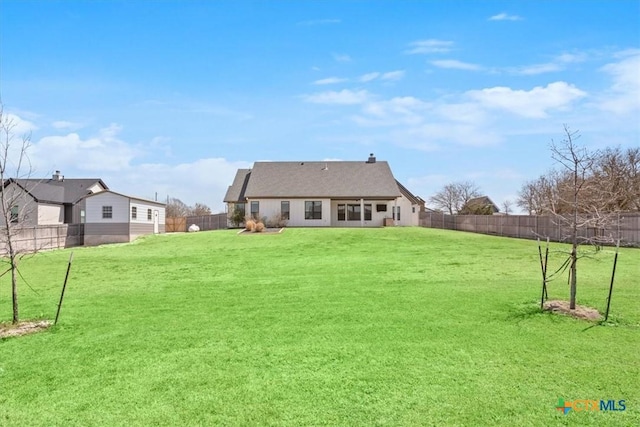 back of property featuring a lawn and a fenced backyard