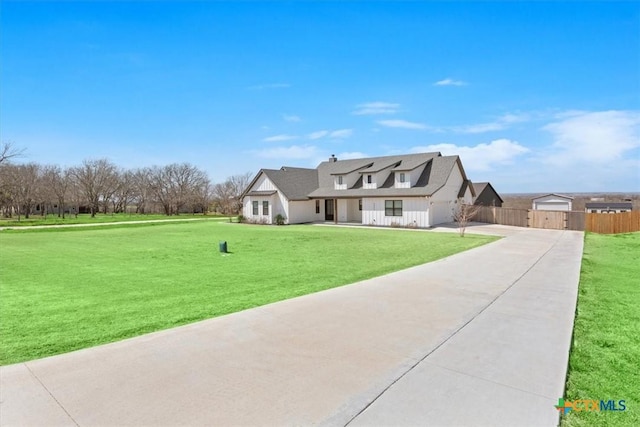 view of front of house with a garage, driveway, a front lawn, and fence