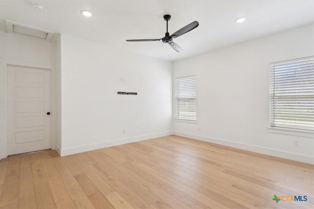 empty room with light wood finished floors, recessed lighting, attic access, and baseboards