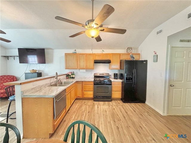 101 N 13th St, Seadrift, TX 77983 - kitchen with gas range, black refrigerator with ice dispenser, ceiling fan, under cabinet range hood, and a sink