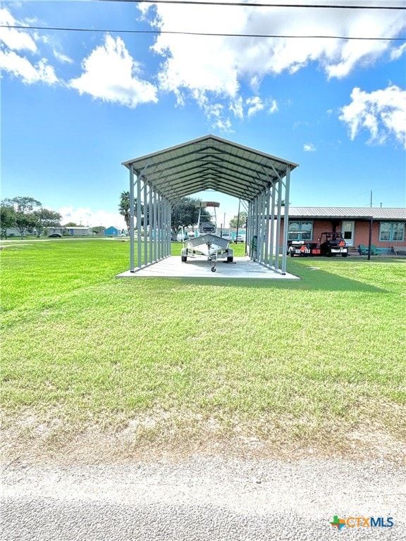 view of vehicle parking featuring a yard and a carport