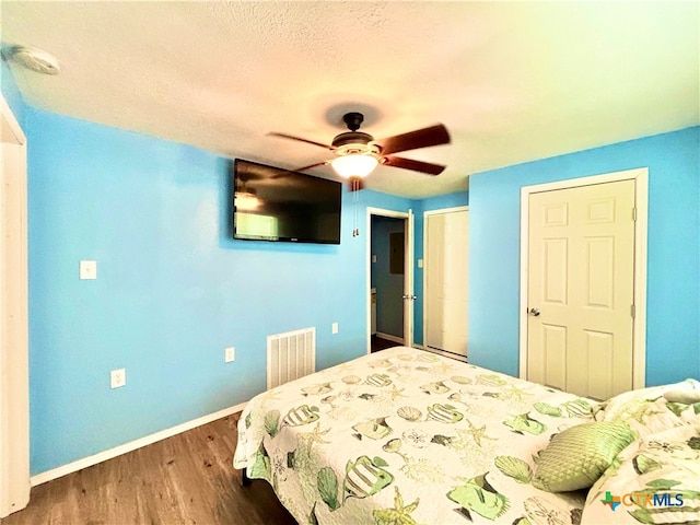 bedroom featuring wood-type flooring, ceiling fan, and a textured ceiling