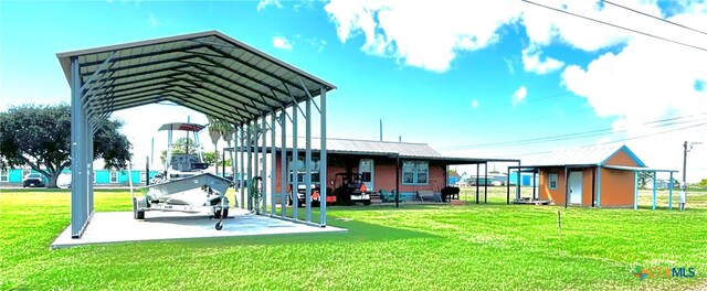 exterior space featuring a lawn, a storage unit, and a carport