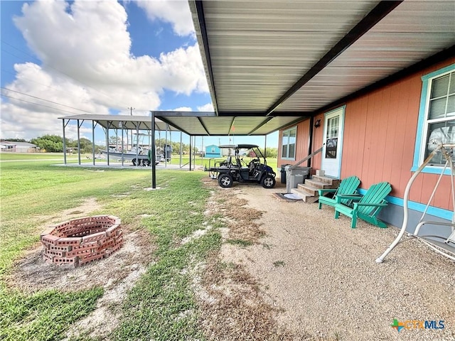 101 N 13th St, Seadrift, TX 77983 - view of grassy yard with entry steps, a carport, and an outdoor fire pit