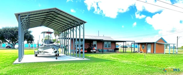 exterior space with an outdoor structure, a yard, and a carport