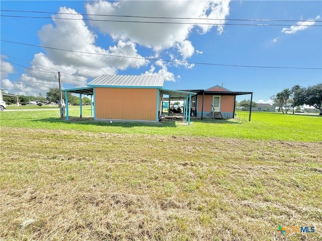 101 N 13th St, Seadrift, TX 77983 - back of property featuring a pole building, a yard, a carport, and an outdoor structure