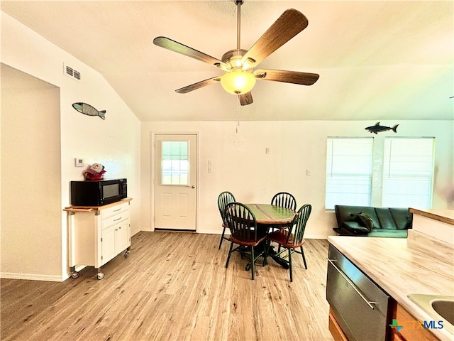 dining space with ceiling fan, light wood-type flooring, and lofted ceiling