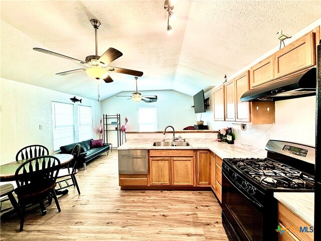 kitchen featuring sink, gas stove, a textured ceiling, lofted ceiling, and light wood-type flooring