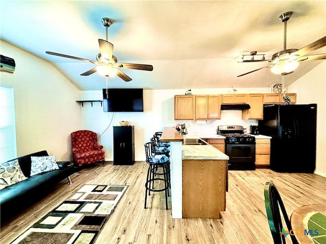 101 N 13th St, Seadrift, TX 77983 - kitchen with range with gas stovetop, freestanding refrigerator, ceiling fan, under cabinet range hood, and vaulted ceiling