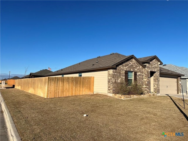 view of property exterior with brick siding, fence, driveway, and an attached garage