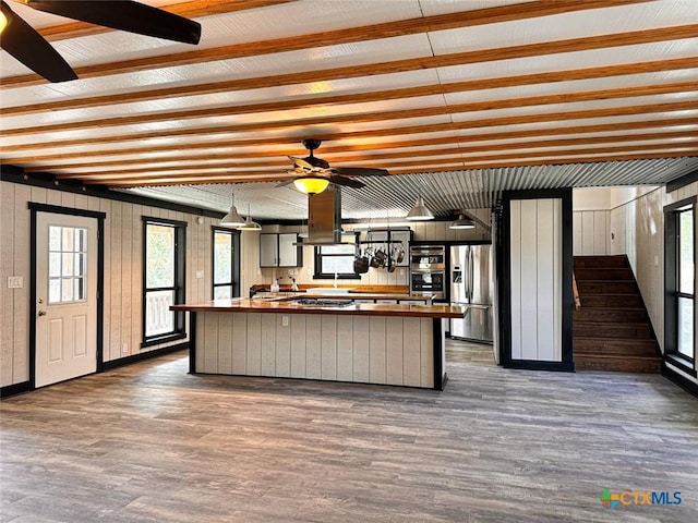 kitchen featuring stainless steel refrigerator with ice dispenser, wood-type flooring, ceiling fan, and butcher block countertops