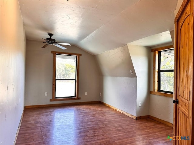 bonus room with hardwood / wood-style flooring and vaulted ceiling