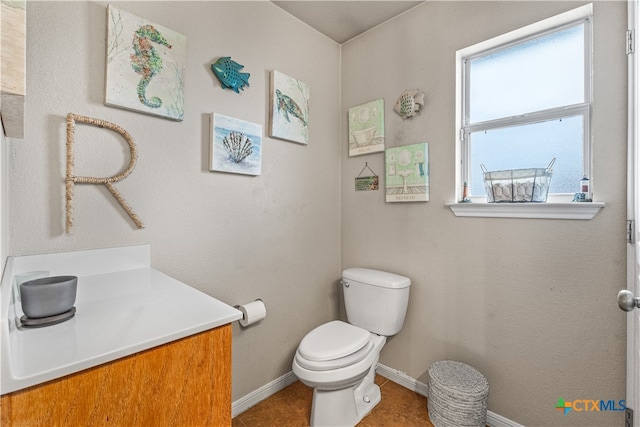 bathroom featuring tile patterned flooring, vanity, toilet, and baseboards