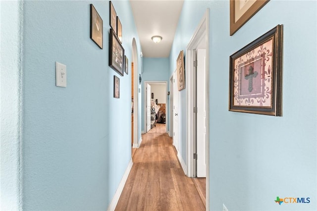 hallway with baseboards and light wood-style floors