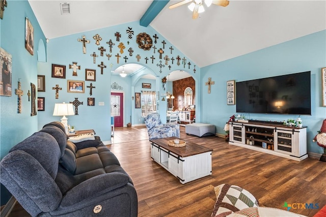 living room featuring visible vents, arched walkways, beam ceiling, and wood finished floors