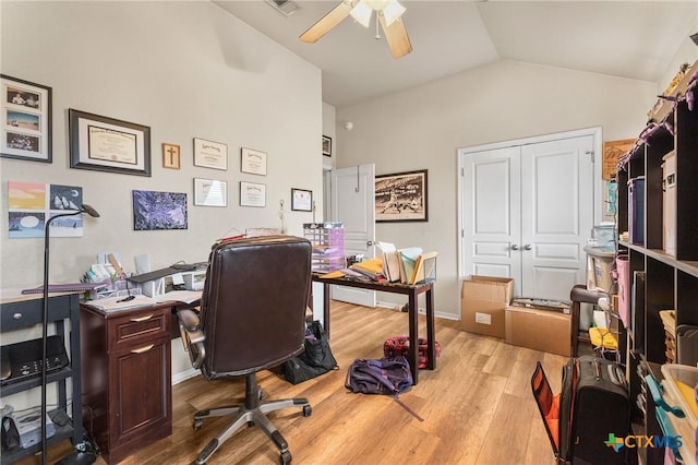 office space featuring a ceiling fan, visible vents, vaulted ceiling, and wood finished floors