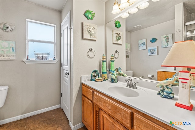 bathroom featuring tile patterned flooring, baseboards, vanity, and toilet