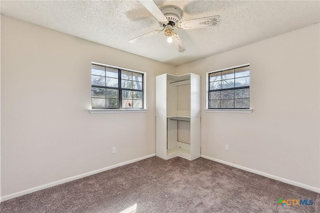 unfurnished bedroom featuring ceiling fan, a textured ceiling, and carpet