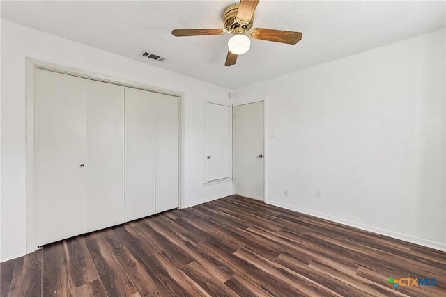 unfurnished bedroom with dark wood-type flooring, a closet, and ceiling fan