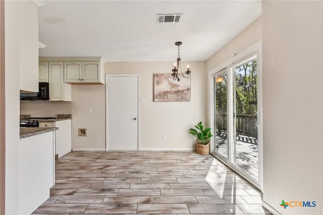 kitchen featuring pendant lighting and a chandelier