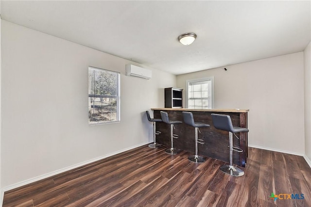 bar with dark wood-type flooring and a wall mounted AC