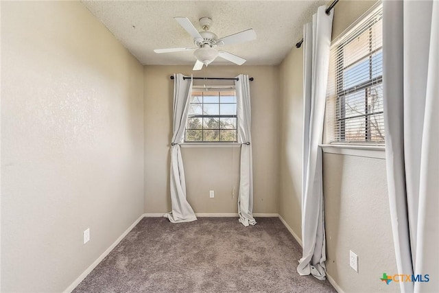 carpeted spare room with a healthy amount of sunlight, ceiling fan, and a textured ceiling