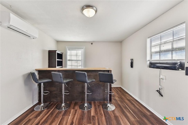 bar featuring dark hardwood / wood-style flooring and a wall mounted air conditioner