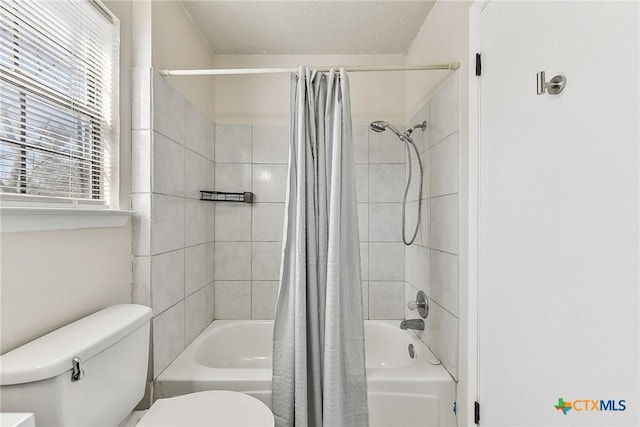 bathroom with shower / bath combination with curtain, a textured ceiling, and toilet