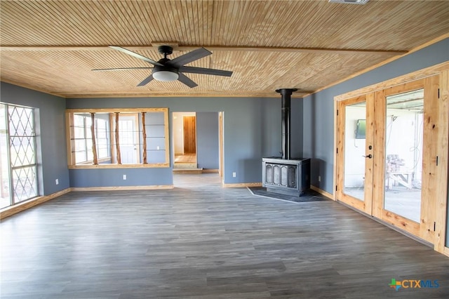 unfurnished living room with ceiling fan, dark hardwood / wood-style floors, wooden ceiling, french doors, and a wood stove