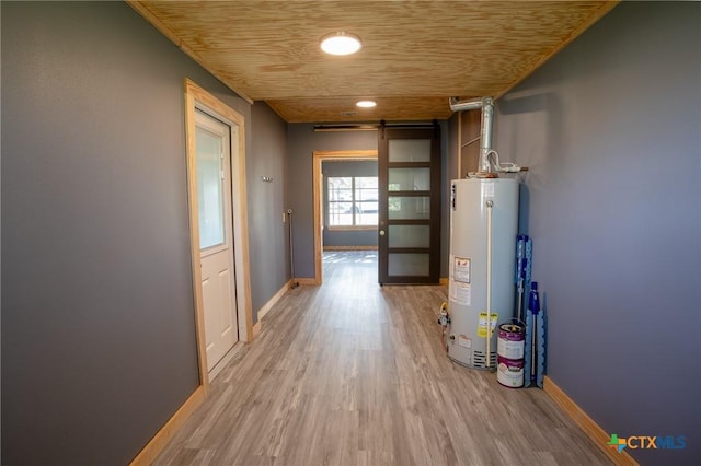 corridor featuring gas water heater, wooden ceiling, a barn door, and light wood-type flooring