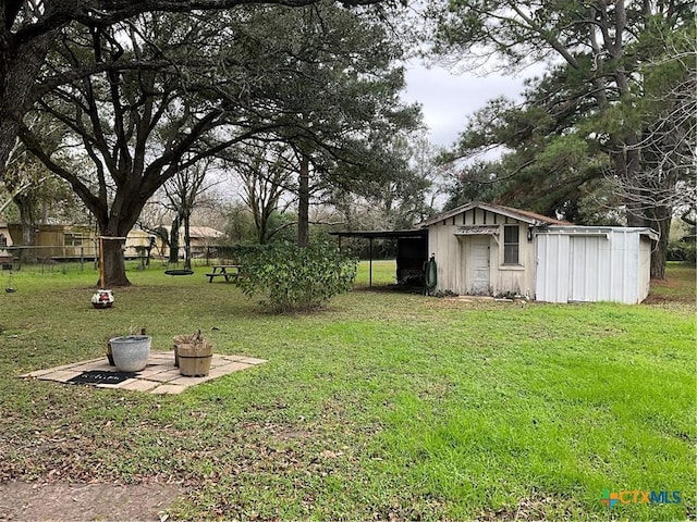 view of yard featuring a carport and an outdoor structure