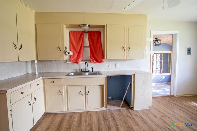 kitchen featuring sink, backsplash, light hardwood / wood-style floors, and ceiling fan