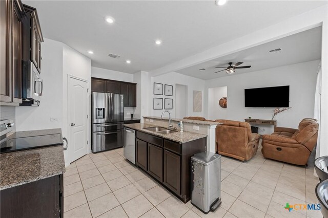 372 Poplin Ln, Troy, TX 76579 - kitchen with appliances with stainless steel finishes, a sink, open floor plan, light tile patterned flooring, and dark brown cabinetry