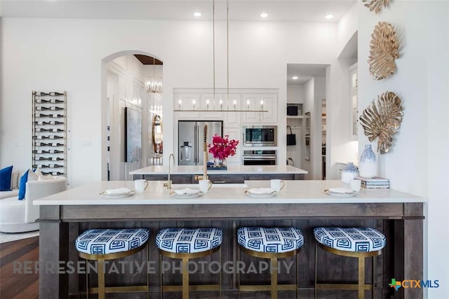 435 Nash Way, New Braunfels, TX 78130 - kitchen featuring an inviting chandelier, white cabinetry, stainless steel appliances, decorative light fixtures, and a kitchen breakfast bar