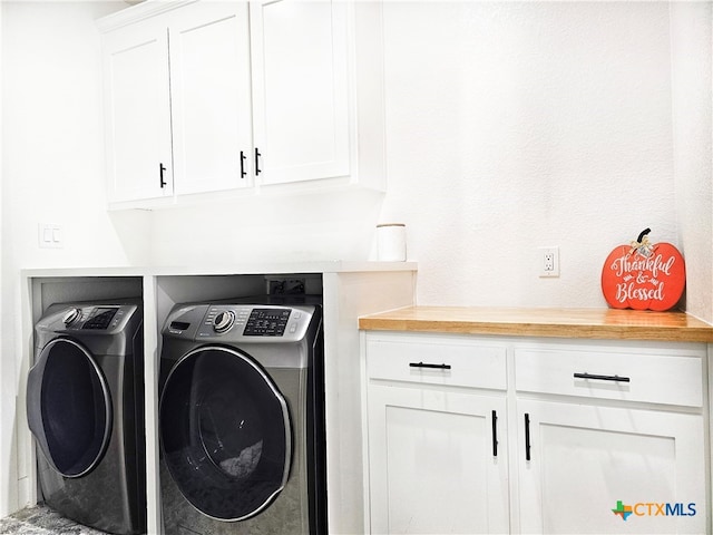 clothes washing area featuring cabinets and washing machine and clothes dryer