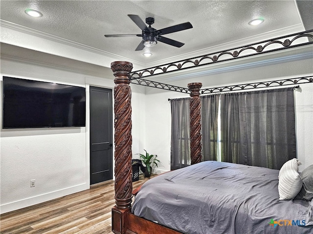 bedroom featuring ceiling fan, wood-type flooring, a textured ceiling, and ornamental molding