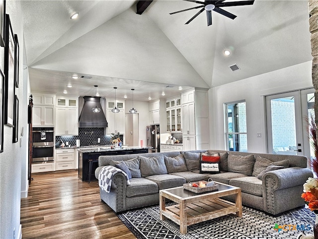 living room featuring beam ceiling, high vaulted ceiling, and dark wood-type flooring