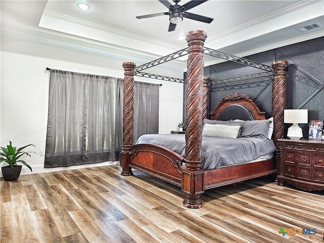 bedroom featuring hardwood / wood-style flooring, ceiling fan, and crown molding