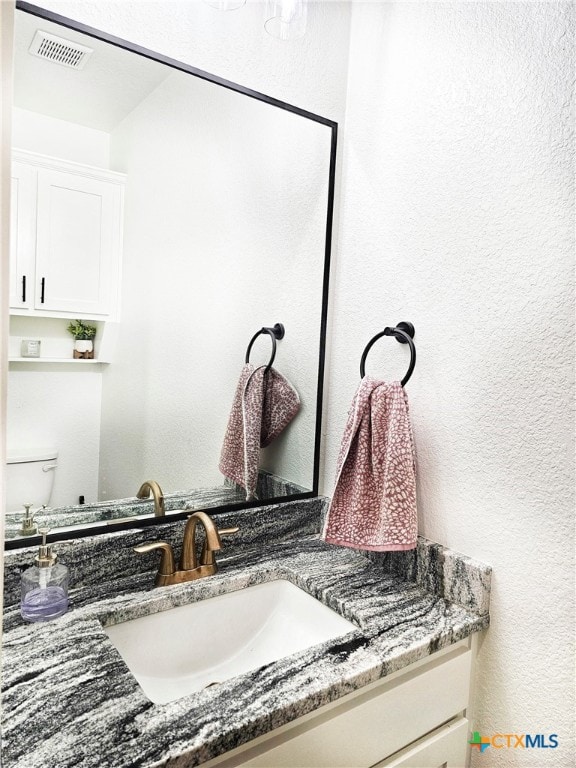 bathroom featuring vanity and toilet