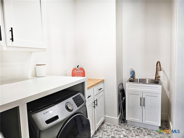 washroom with cabinets, washer / clothes dryer, and sink