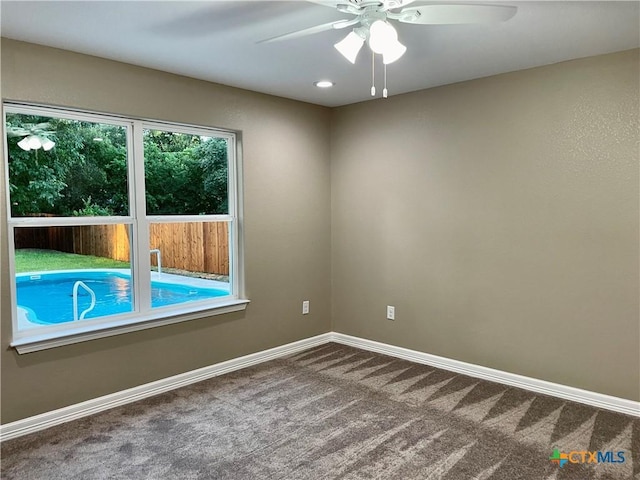 carpeted empty room featuring ceiling fan