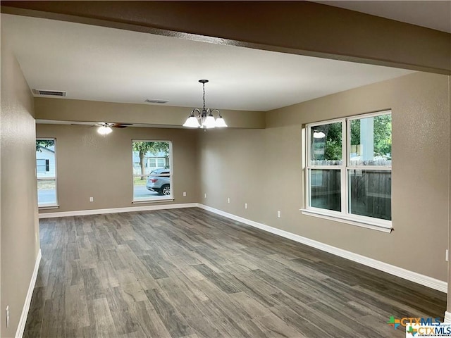 unfurnished dining area with hardwood / wood-style floors, ceiling fan with notable chandelier, and a healthy amount of sunlight